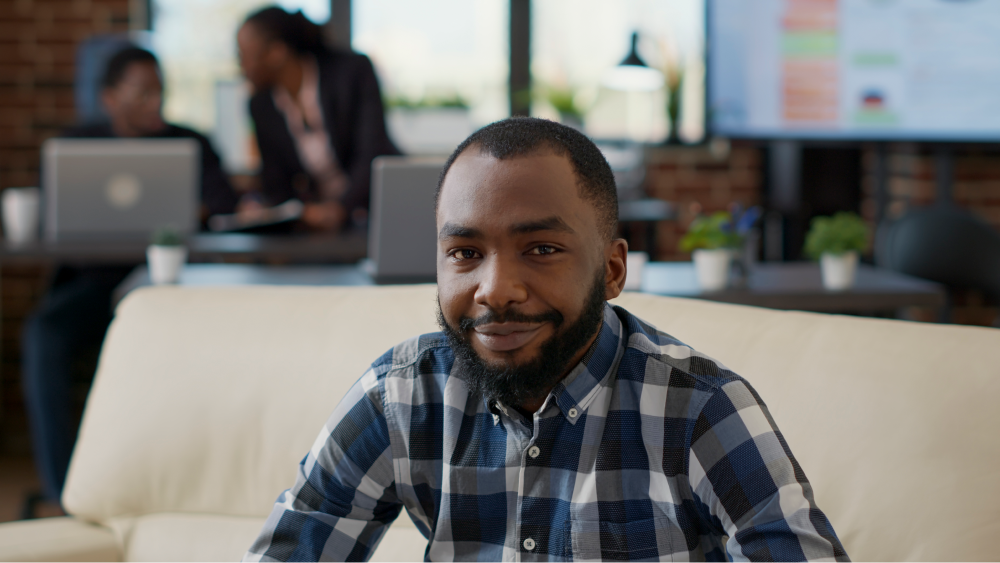 portrait-african-american-person-smiling-office-sitting-couch-work-laptop-company-employee-using-financial-statistics-create-job-development-business-growth